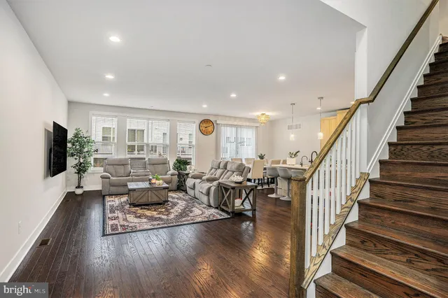 a living room with furniture flat screen tv and wooden floor