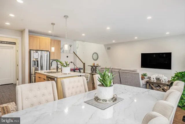 a living room with furniture kitchen view and a potted plant