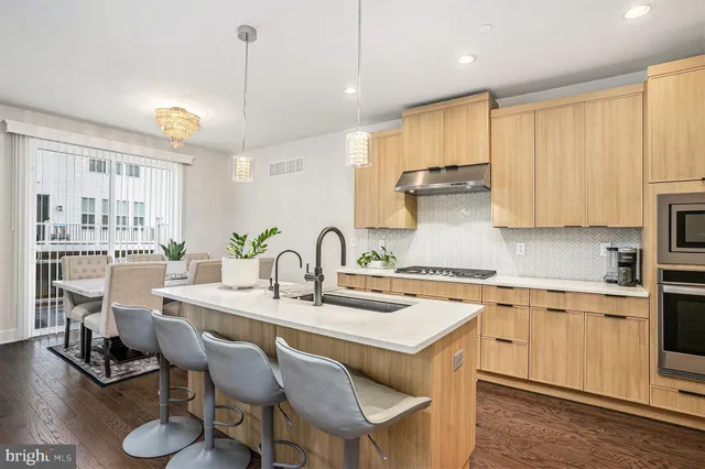 a kitchen with a sink stove and white cabinets with wooden floor