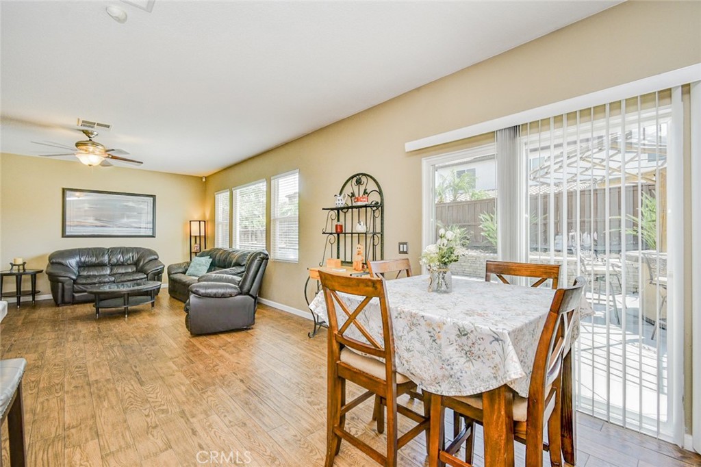 6174 Risingstar Drive Eastvale, CA 92880 - Photo 11 of 57 a view of a dining room with furniture a chandelier and wooden floor