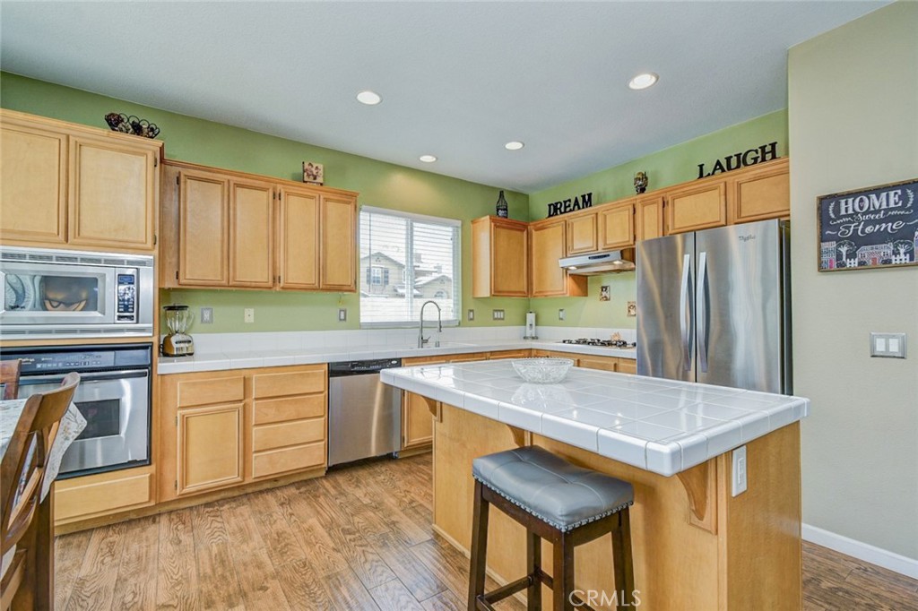 6174 Risingstar Drive Eastvale, CA 92880 - Photo 12 of 57 a kitchen with a refrigerator a sink and cabinets