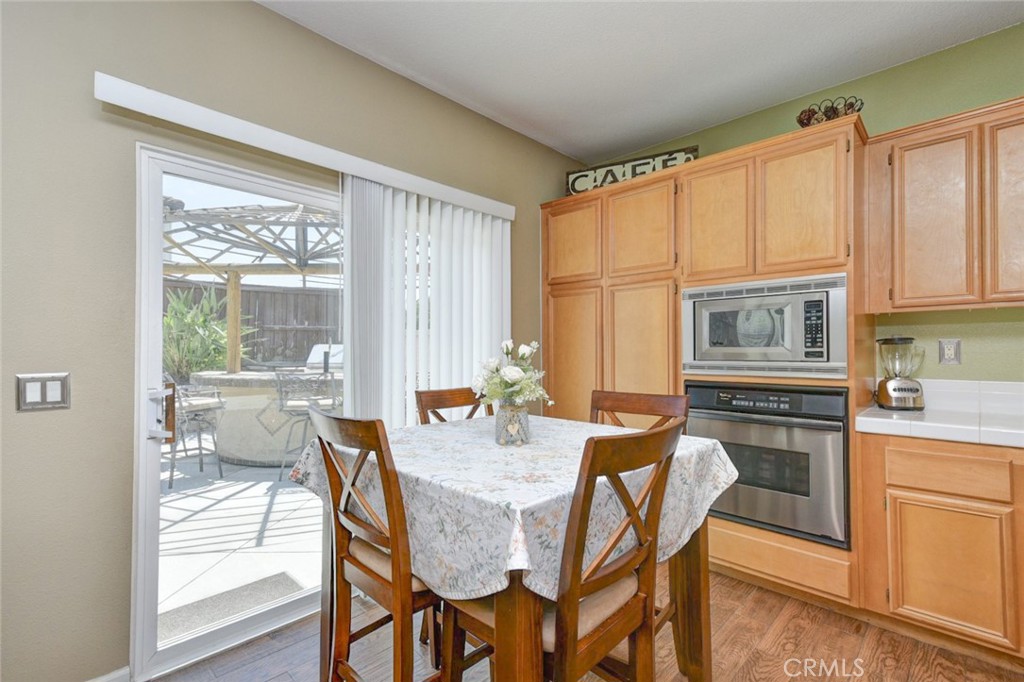 6174 Risingstar Drive Eastvale, CA 92880 - Photo 13 of 57 a dining room with furniture a chandelier and wooden floor