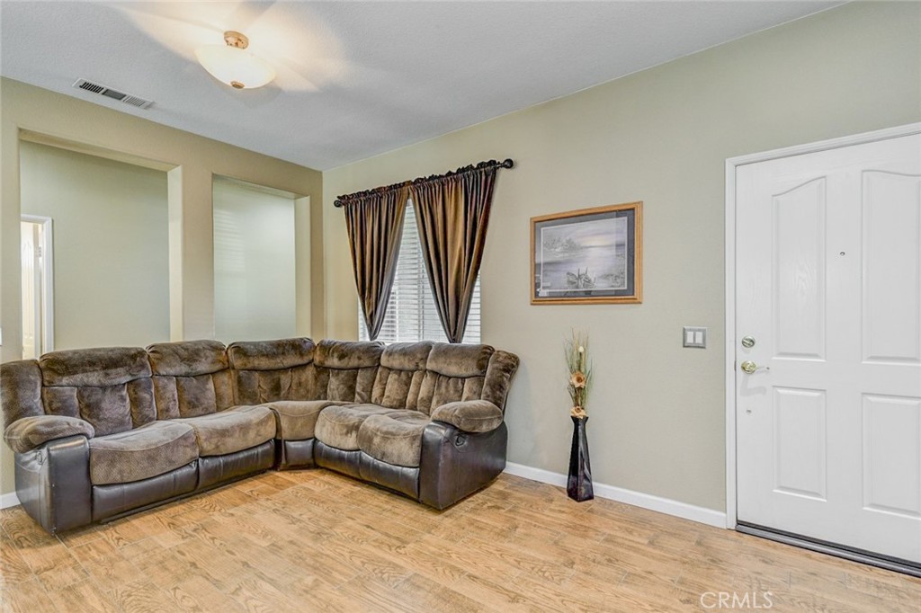 6174 Risingstar Drive Eastvale, CA 92880 - Photo 15 of 57 a living room with a couch and a window