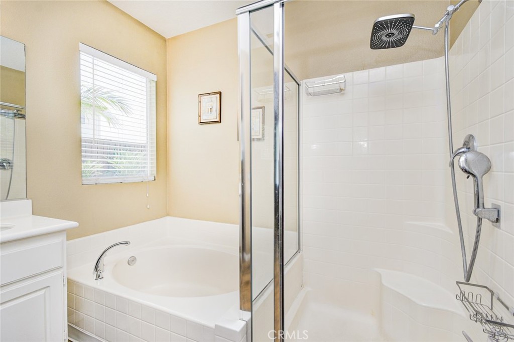 6174 Risingstar Drive Eastvale, CA 92880 - Photo 21 of 57 a bathroom with a bathtub and a shower