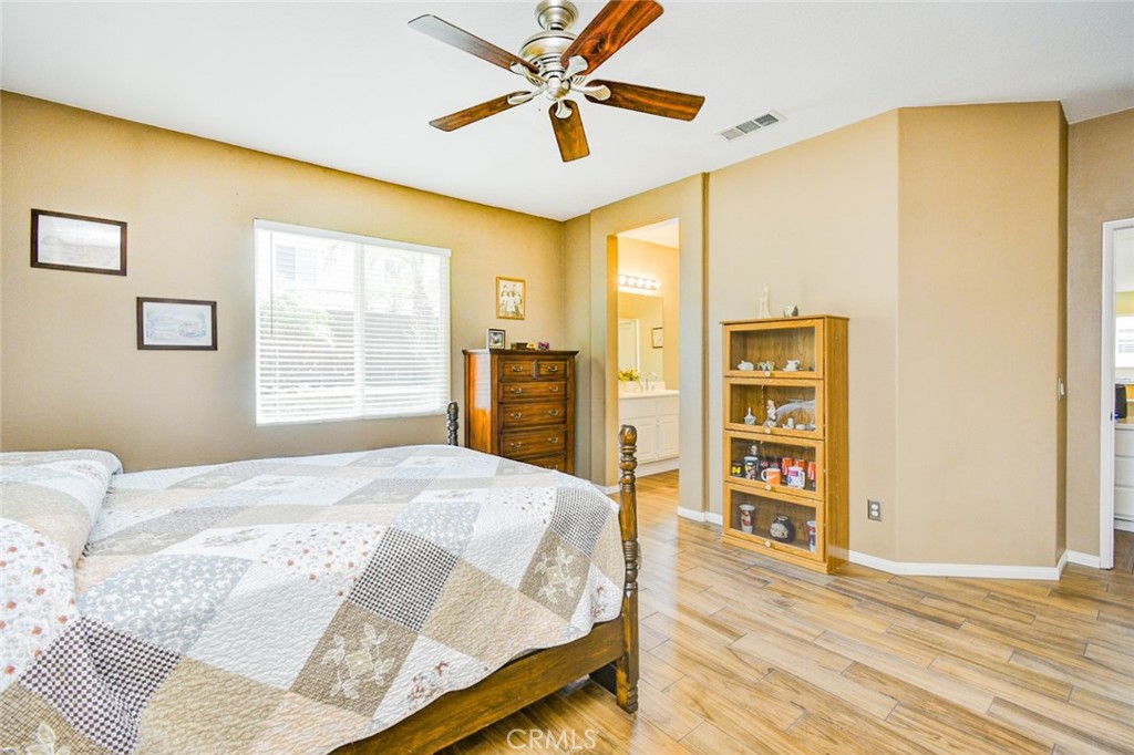 6174 Risingstar Drive Eastvale, CA 92880 - Photo 25 of 57 a bedroom with a bed and wooden floor