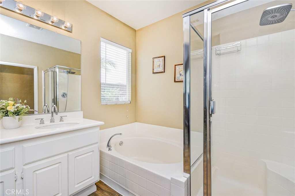 6174 Risingstar Drive Eastvale, CA 92880 - Photo 27 of 57 a bathroom with a granite countertop sink mirror and a bathtub