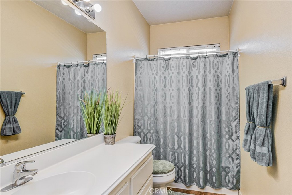 6174 Risingstar Drive Eastvale, CA 92880 - Photo 36 of 57 a bathroom with a sink a toilet and a tub