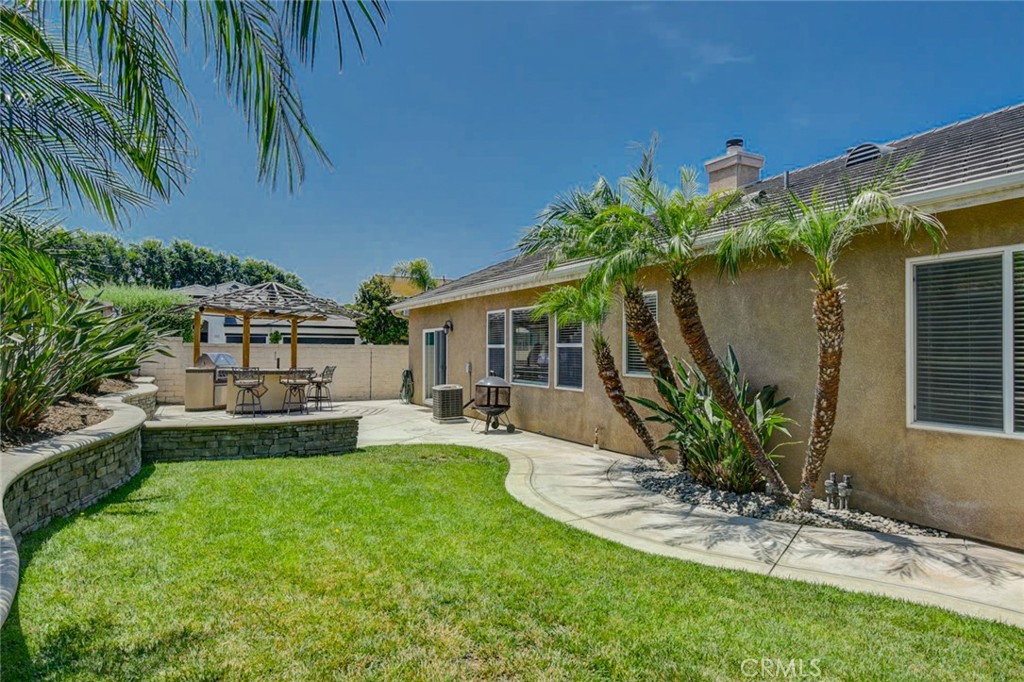 6174 Risingstar Drive Eastvale, CA 92880 - Photo 43 of 57 a front view of a house with garden and patio