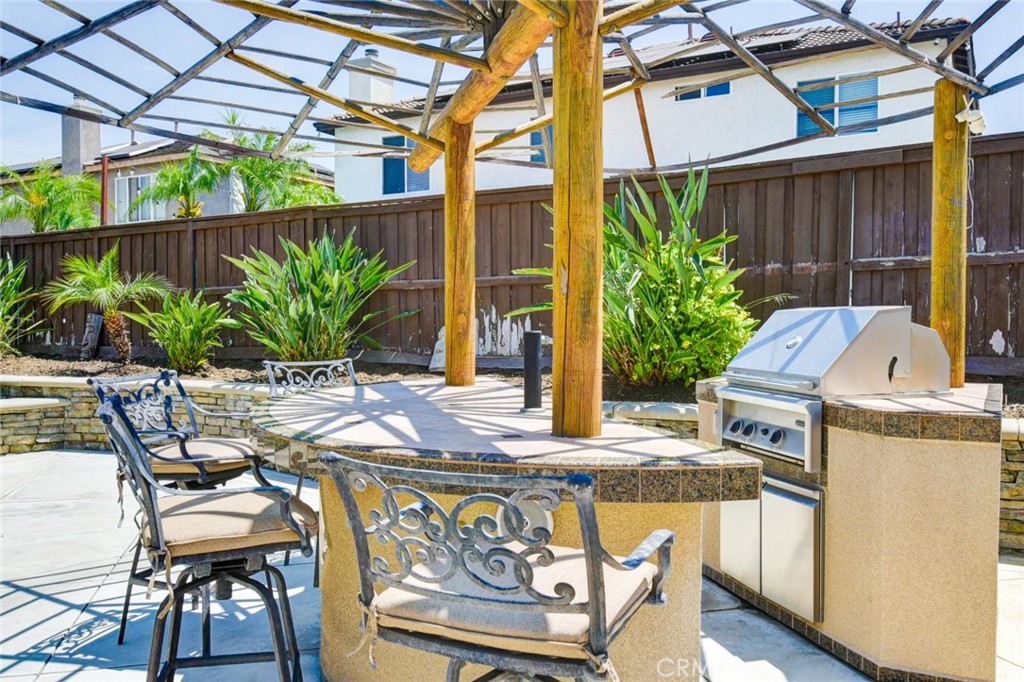 6174 Risingstar Drive Eastvale, CA 92880 - Photo 48 of 57 a view of a patio with table and chairs potted plants with wooden floor