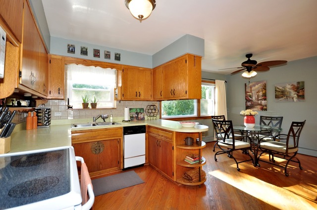 50 West Avenue, Unit 2N Riverside, IL 60546 - Photo 12 of 18 a open kitchen with stainless steel appliances granite countertop a stove top oven a dining table and chairs with wooden floor