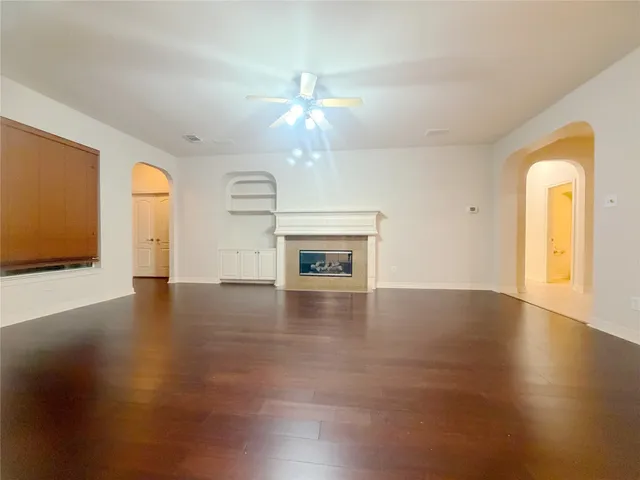 a view of an empty room with window and wooden floor