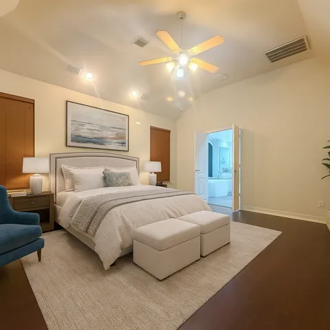 a bedroom with a large bed and a chandelier