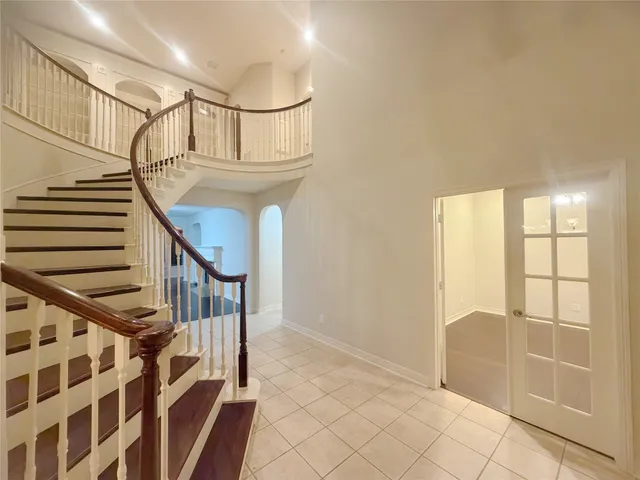 a view of staircase with white walls and fan