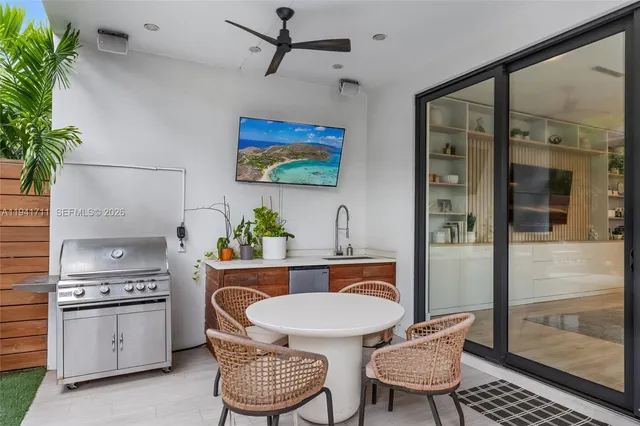 a wooden bench sitting in backside of a house with potted plants