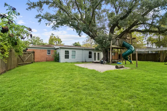 a view of a house with backyard and a tree