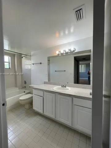 a bathroom with a double vanity sink toilet and shower