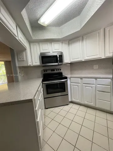 a kitchen with a sink a stove and cabinets