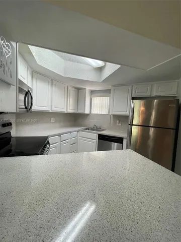 a kitchen with stainless steel appliances granite countertop a refrigerator sink and cabinets