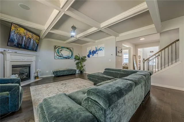 a open kitchen with stainless steel appliances granite countertop a stove a refrigerator a microwave a dining table and chairs with wooden floor