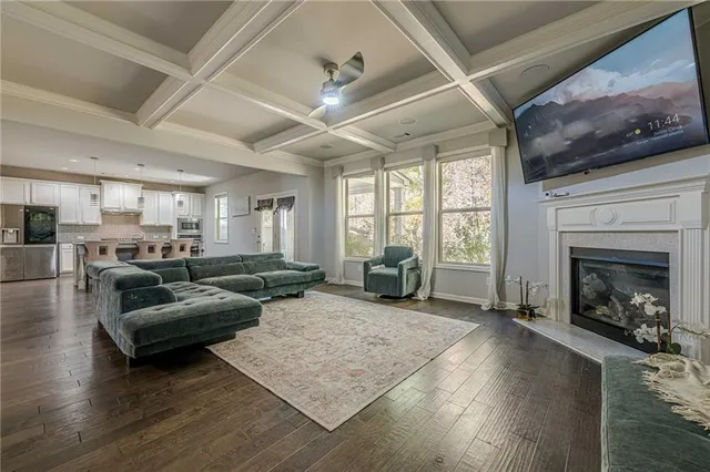 a kitchen with stainless steel appliances granite countertop a stove top oven a sink a dining table and chairs with wooden floor