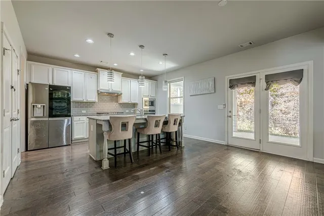 a kitchen with granite countertop white cabinets and stainless steel appliances