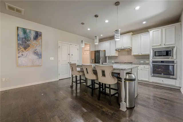 a kitchen with granite countertop a sink and a stove top oven