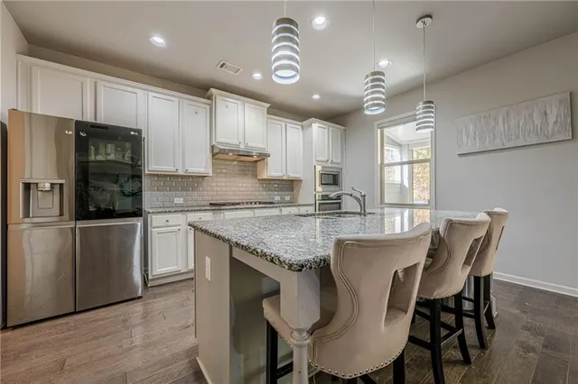 a kitchen with granite countertop cabinets and steel stainless steel appliances