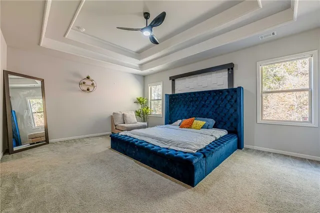 a bedroom with a bed mirror and a ceiling fan