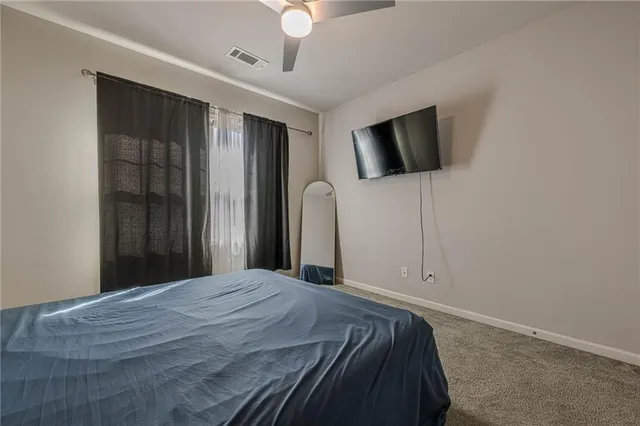 a bedroom with a bed and a ceiling fan