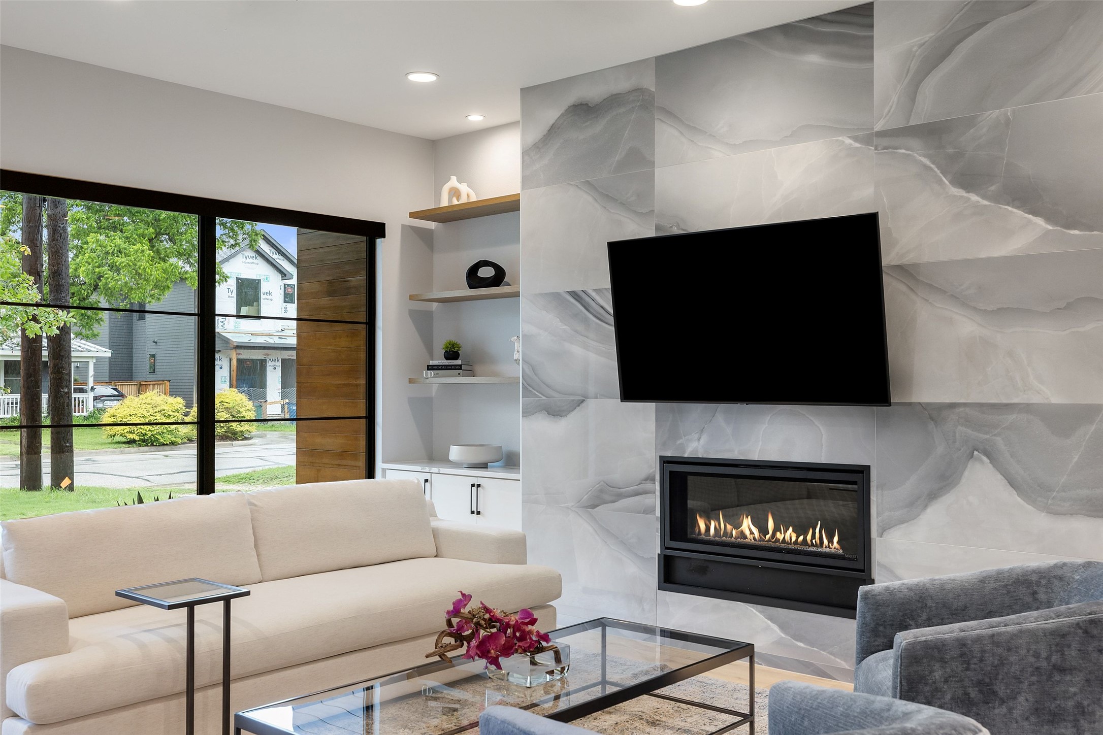 5405 Montview Street Austin, TX 78756 - Photo 14 of 40 Elegant living space features a modern fireplace set into a sophisticated tiled wall, bathed in natural illumination.