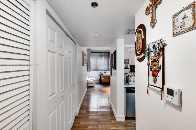 a hallway with painting on the wall and a potted plant