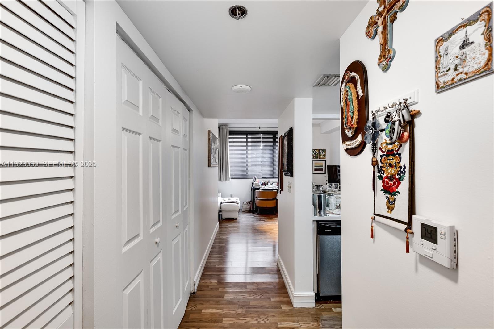 540 Brickell Key Drive, Unit 210 Miami, FL 33131 - Photo 4 of 12 a hallway with painting on the wall and a potted plant