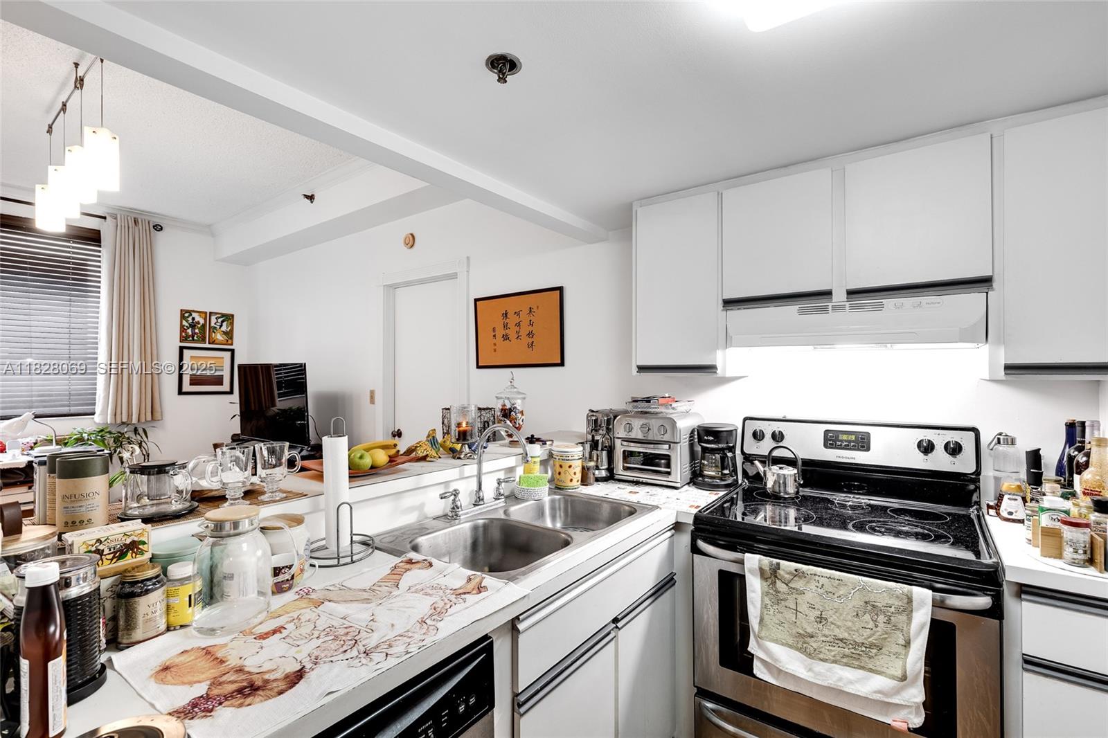 540 Brickell Key Drive, Unit 210 Miami, FL 33131 - Photo 6 of 12 a kitchen with stainless steel appliances a stove a sink dishwasher and cabinets with wooden floor