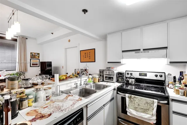 a kitchen with stainless steel appliances a stove a sink dishwasher and cabinets with wooden floor