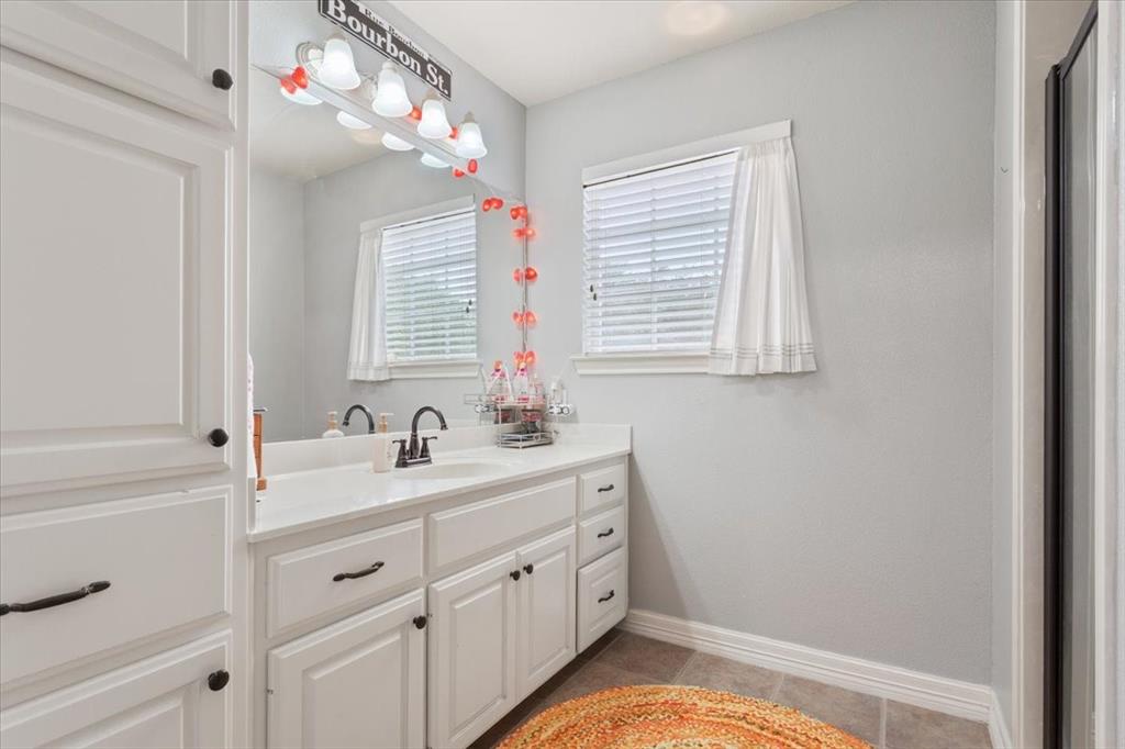 5616 Landsdown Drive Waco, TX 76708 - Photo 24 of 33 a bathroom with a sink vanity granite tub and a mirror