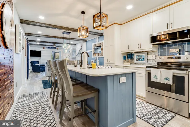 a kitchen with stainless steel appliances a sink a stove a refrigerator and cabinets