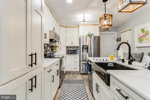 a view of kitchen with refrigerator stove and wooden floor