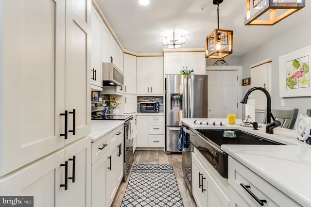 a view of kitchen with refrigerator stove and wooden floor