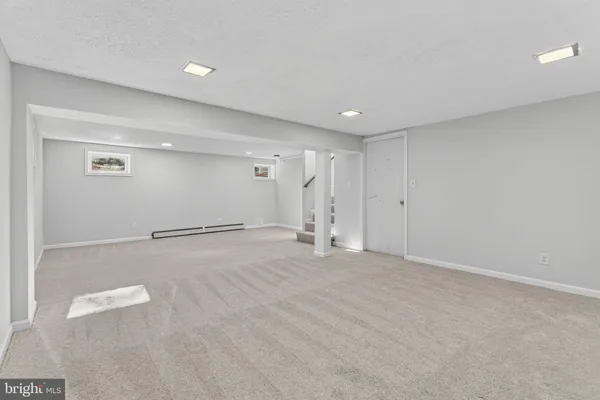 a view of a house with a big yard plants and large trees