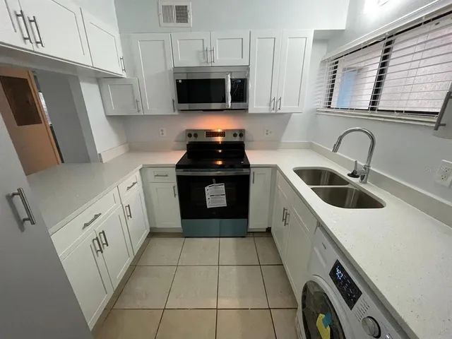 a kitchen with a stove sink and a microwave
