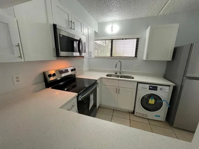 a kitchen with a stove a sink and a microwave