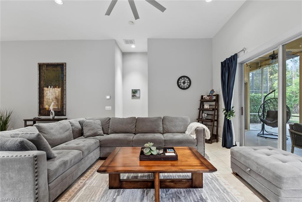 6051 Shallows Way Naples, FL 34109 - Photo 13 of 38 a living room with furniture wooden floor and a large window