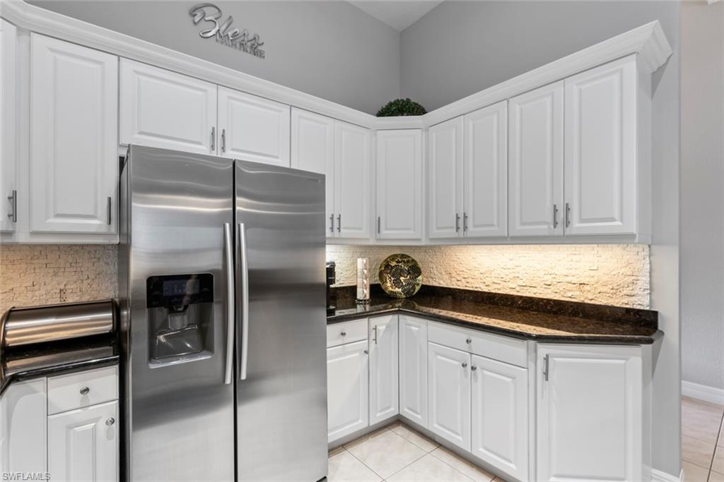 6051 Shallows Way Naples, FL 34109 - Photo 15 of 38 a kitchen with a refrigerator and cabinets
