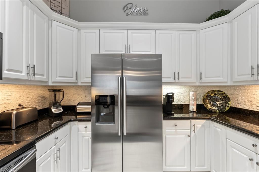 6051 Shallows Way Naples, FL 34109 - Photo 16 of 38 a kitchen with refrigerator and cabinets