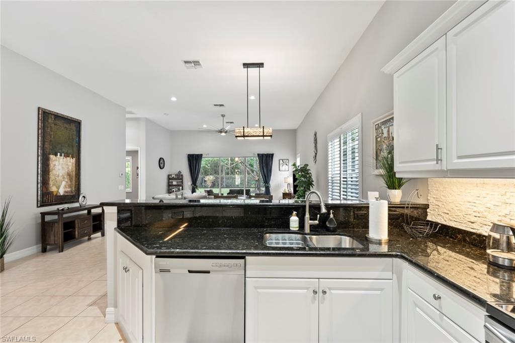 6051 Shallows Way Naples, FL 34109 - Photo 19 of 38 a kitchen with a sink and cabinets