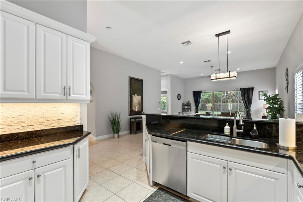 6051 Shallows Way Naples, FL 34109 - Photo 20 of 38 a kitchen with granite countertop a sink and white cabinets