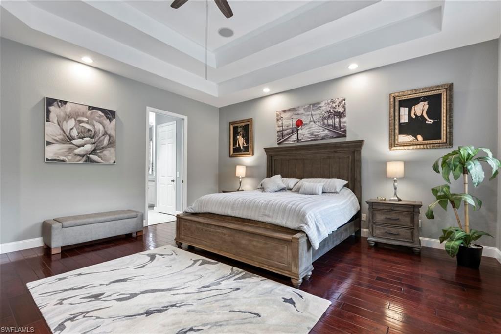 6051 Shallows Way Naples, FL 34109 - Photo 22 of 38 a bedroom with a large bed and a chandelier