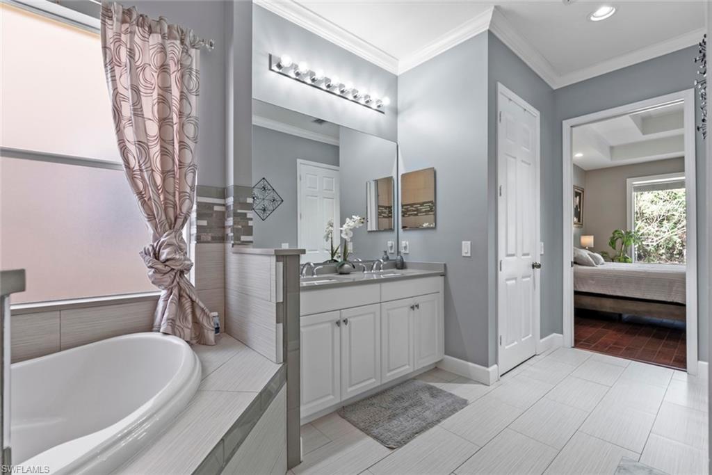 6051 Shallows Way Naples, FL 34109 - Photo 27 of 38 a spacious bathroom with a granite countertop sink a mirror and a bathtub