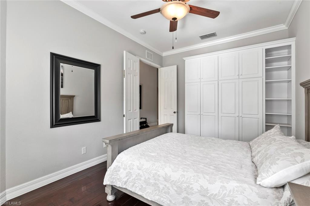 6051 Shallows Way Naples, FL 34109 - Photo 29 of 38 a bedroom with a large bed and a chandelier