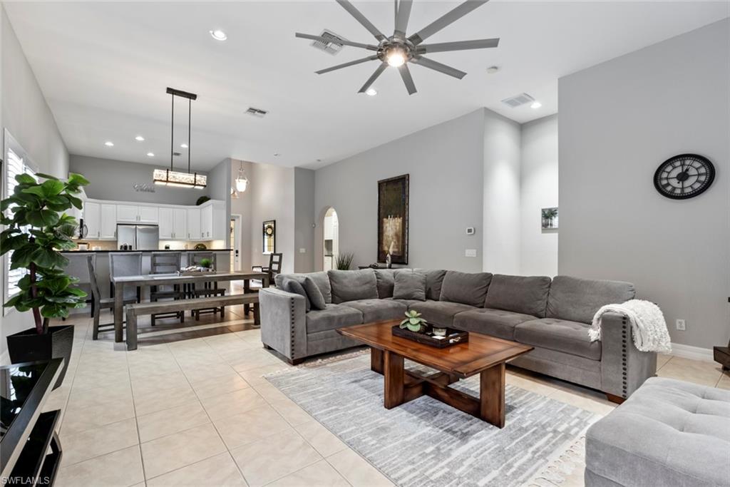 6051 Shallows Way Naples, FL 34109 - Photo 10 of 38 a living room with furniture kitchen view and a chandelier